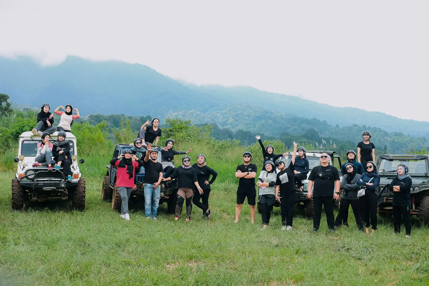 Peserta Find Adventure berfoto bersama jeep di padang rumput dengan latar gunung