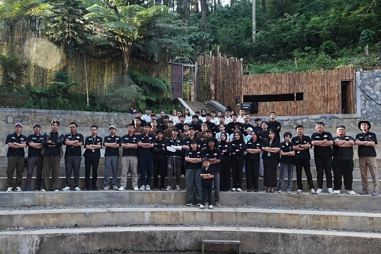 Seluruh tim Petualang Group bersedekap di tangga amfiteater di tengah hutan